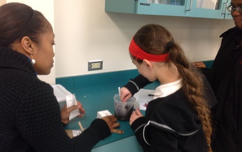 student and teacher work with plant